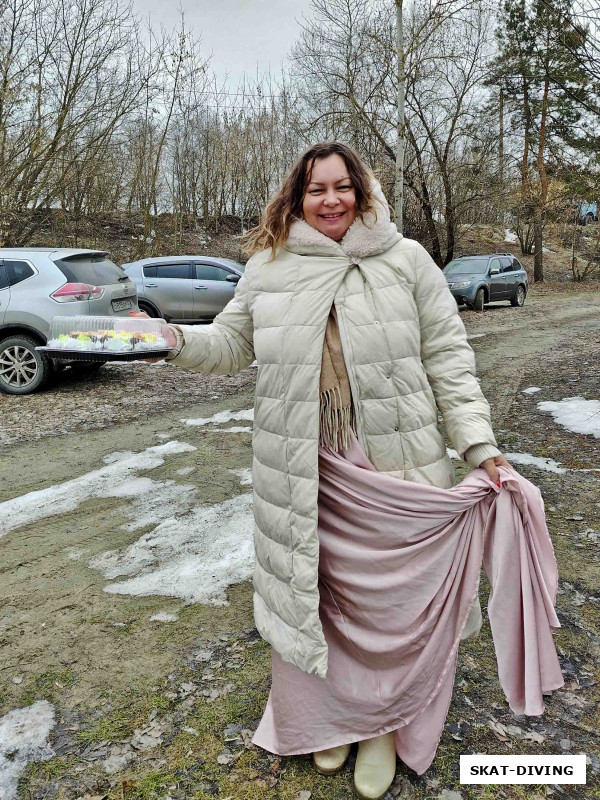 Новикова Оксана, вышла из машины с угощением в руках и вечернем платье под пальто