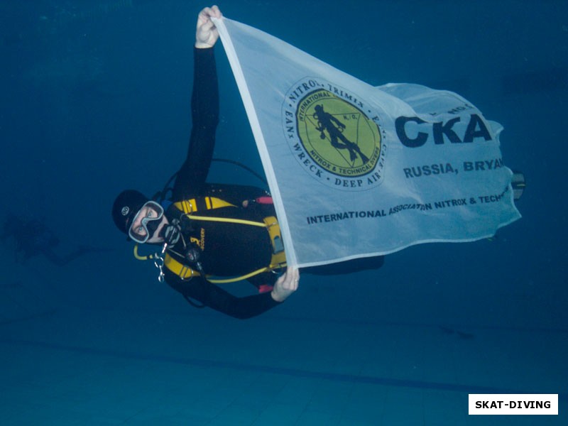 Кирюхин Роман, несет в руках флаг клуба «Скат» для памятной фотографии