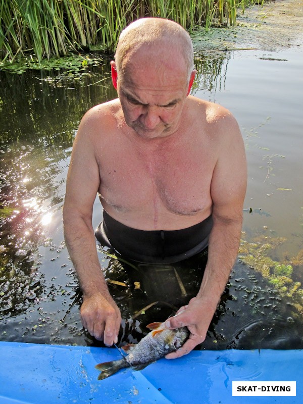 Семененко Андрей, готовит добытую в реке рыбку для ухи