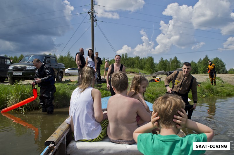 Взрослые провожают детей на прогулку в лодке