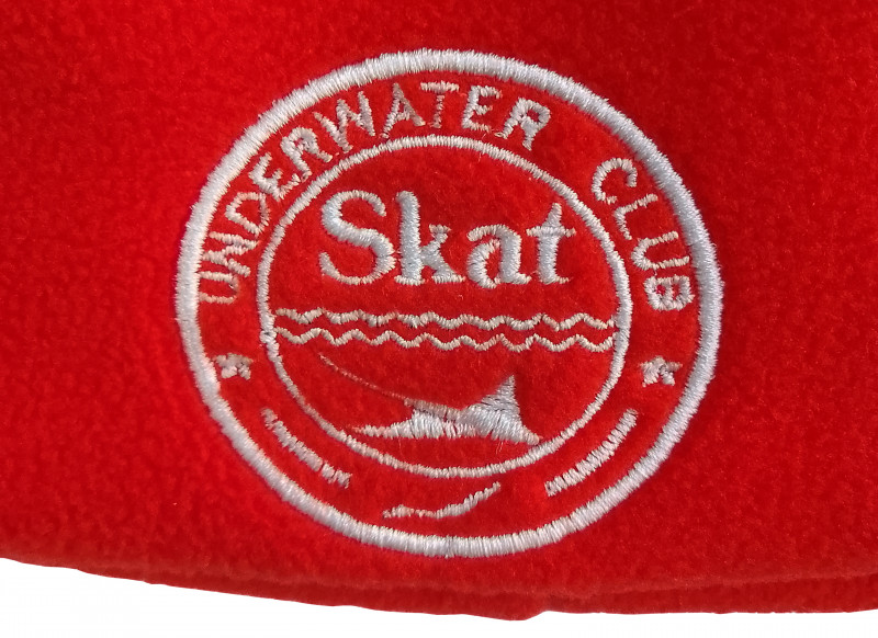Яркий головной убор красного цвета с фирменным логотипом клуба во лбу