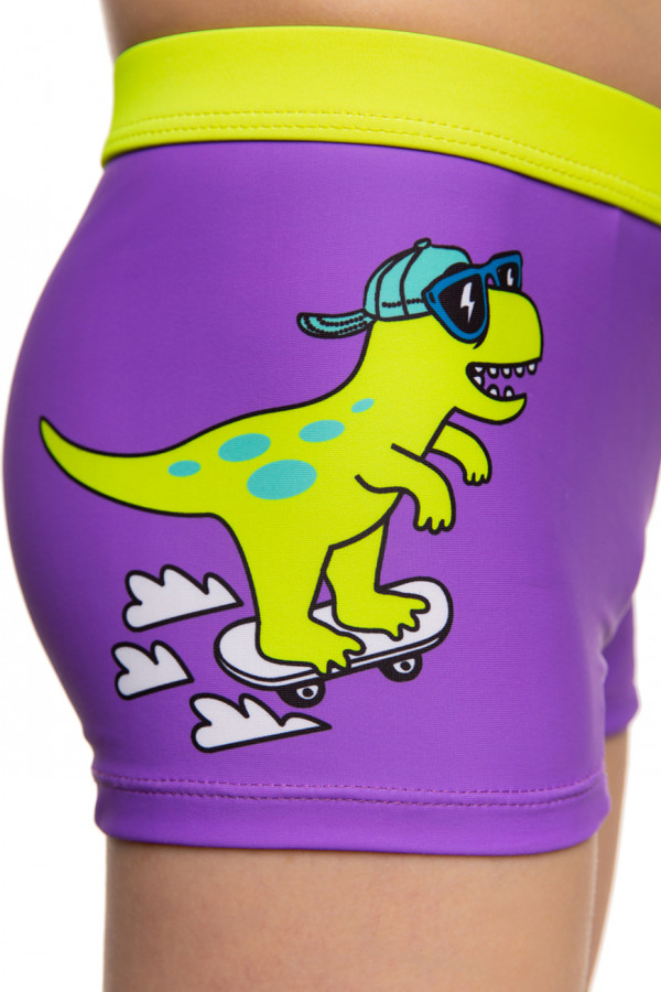 На плавках расположен рисунок в виде веселого динозавра на скейтборде